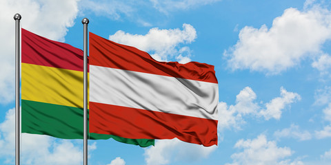 Bolivia and Austria flag waving in the wind against white cloudy blue sky together. Diplomacy concept, international relations.