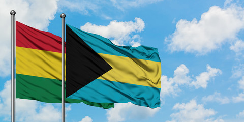 Bolivia and Bahamas flag waving in the wind against white cloudy blue sky together. Diplomacy concept, international relations.