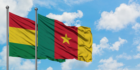 Bolivia and Cameroon flag waving in the wind against white cloudy blue sky together. Diplomacy concept, international relations.