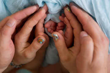 little feet a newborn baby boy. Legs on blue background, ,soft focus