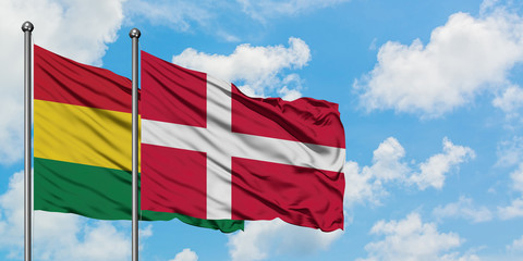 Bolivia and Denmark flag waving in the wind against white cloudy blue sky together. Diplomacy concept, international relations.