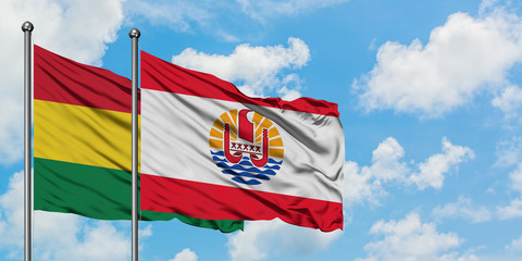Bolivia and French Polynesia flag waving in the wind against white cloudy blue sky together. Diplomacy concept, international relations.
