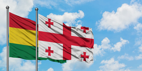 Bolivia and Georgia flag waving in the wind against white cloudy blue sky together. Diplomacy concept, international relations.