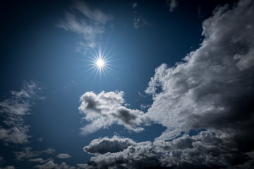 Naklejka na ściany i meble Sun shining in the cloudy sky.