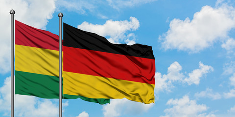 Bolivia and Germany flag waving in the wind against white cloudy blue sky together. Diplomacy concept, international relations.