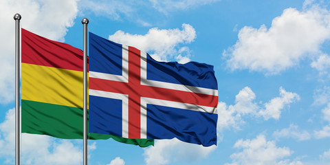 Bolivia and Iceland flag waving in the wind against white cloudy blue sky together. Diplomacy...