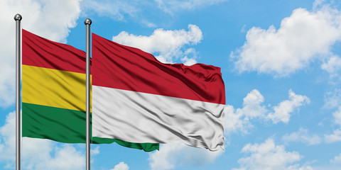 Bolivia and Indonesia flag waving in the wind against white cloudy blue sky together. Diplomacy concept, international relations.