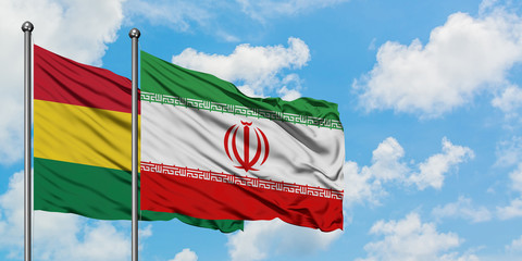 Bolivia and Iran flag waving in the wind against white cloudy blue sky together. Diplomacy concept, international relations.