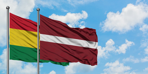 Bolivia and Latvia flag waving in the wind against white cloudy blue sky together. Diplomacy concept, international relations.