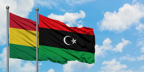 Bolivia and Libya flag waving in the wind against white cloudy blue sky together. Diplomacy concept, international relations.