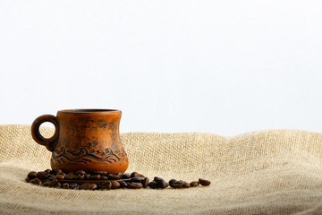 A cup of coffee and grains are burlap. Space for inscription