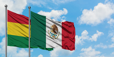 Bolivia and Mexico flag waving in the wind against white cloudy blue sky together. Diplomacy concept, international relations.