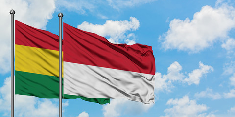 Bolivia and Monaco flag waving in the wind against white cloudy blue sky together. Diplomacy concept, international relations.