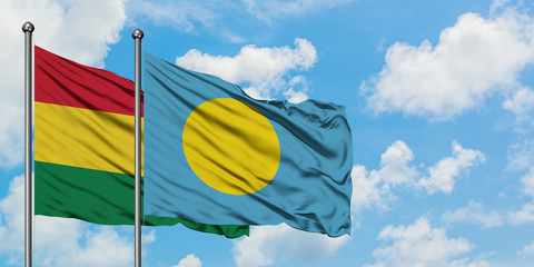 Bolivia and Palau flag waving in the wind against white cloudy blue sky together. Diplomacy concept, international relations.