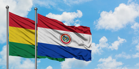 Bolivia and Paraguay flag waving in the wind against white cloudy blue sky together. Diplomacy concept, international relations.