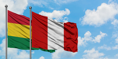 Bolivia and Peru flag waving in the wind against white cloudy blue sky together. Diplomacy concept, international relations.