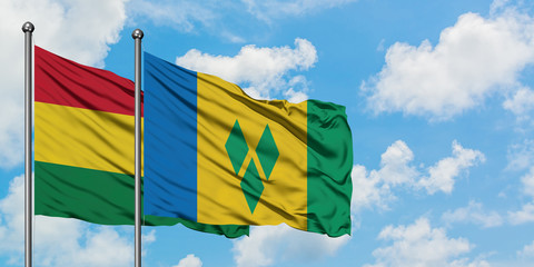 Bolivia and Saint Vincent And The Grenadines flag waving in the wind against white cloudy blue sky...