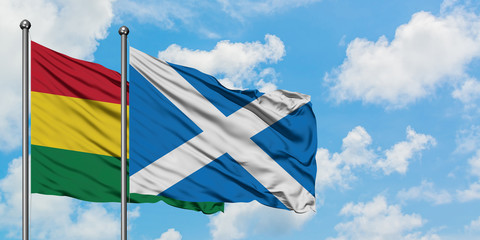 Bolivia and Scotland flag waving in the wind against white cloudy blue sky together. Diplomacy concept, international relations.