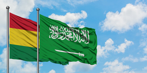 Bolivia and Saudi Arabia flag waving in the wind against white cloudy blue sky together. Diplomacy concept, international relations.