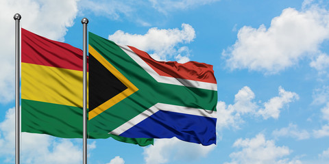 Bolivia and South Africa flag waving in the wind against white cloudy blue sky together. Diplomacy concept, international relations.