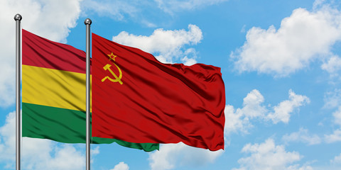 Bolivia and Soviet Union flag waving in the wind against white cloudy blue sky together. Diplomacy concept, international relations.