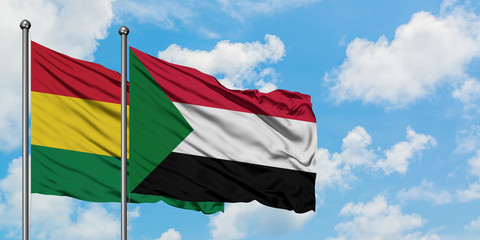 Bolivia and Sudan flag waving in the wind against white cloudy blue sky together. Diplomacy concept, international relations.