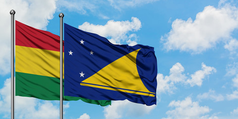 Bolivia and Tokelau flag waving in the wind against white cloudy blue sky together. Diplomacy...
