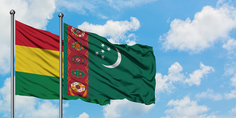 Bolivia and Turkmenistan flag waving in the wind against white cloudy blue sky together. Diplomacy...