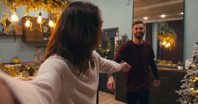 Phone camera POV Caucasian couple or family having a video call with friends or family during Christmas holidays. 4K UHD RAW graded footage