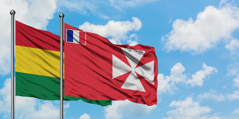 Bolivia and Wallis And Futuna flag waving in the wind against white cloudy blue sky together. Diplomacy concept, international relations.