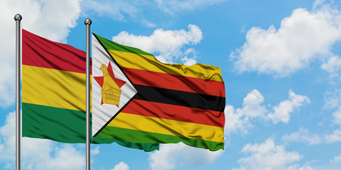 Bolivia and Zimbabwe flag waving in the wind against white cloudy blue sky together. Diplomacy concept, international relations.