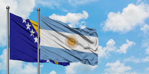 Bosnia Herzegovina and Argentina flag waving in the wind against white cloudy blue sky together. Diplomacy concept, international relations.