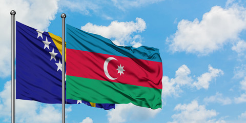 Bosnia Herzegovina and Azerbaijan flag waving in the wind against white cloudy blue sky together....