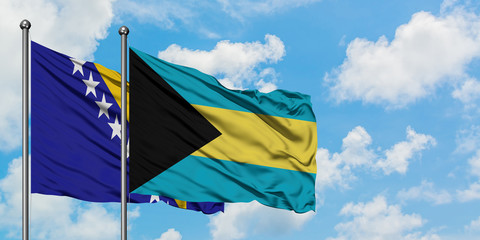 Bosnia Herzegovina and Bahamas flag waving in the wind against white cloudy blue sky together. Diplomacy concept, international relations.