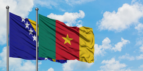 Bosnia Herzegovina and Cameroon flag waving in the wind against white cloudy blue sky together. Diplomacy concept, international relations.