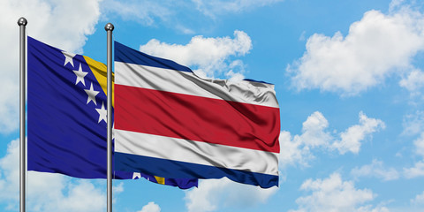Bosnia Herzegovina and Costa Rica flag waving in the wind against white cloudy blue sky together. Diplomacy concept, international relations.