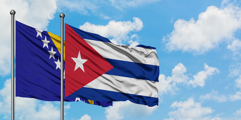 Bosnia Herzegovina and Cuba flag waving in the wind against white cloudy blue sky together. Diplomacy concept, international relations.