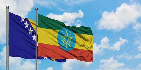 Bosnia Herzegovina and Ethiopia flag waving in the wind against white cloudy blue sky together. Diplomacy concept, international relations.