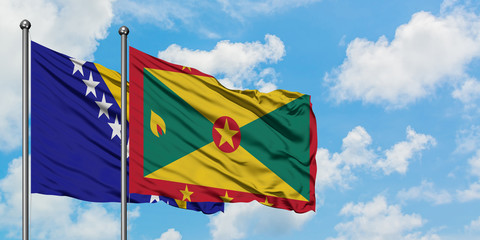 Bosnia Herzegovina and Grenada flag waving in the wind against white cloudy blue sky together....