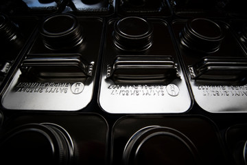 stainless steel jerry cans stacked in warehouse, close up with shallow depth of field 
