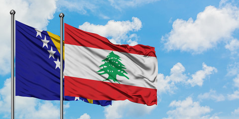 Bosnia Herzegovina and Lebanon flag waving in the wind against white cloudy blue sky together. Diplomacy concept, international relations.