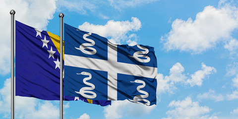 Bosnia Herzegovina and Martinique flag waving in the wind against white cloudy blue sky together. Diplomacy concept, international relations.