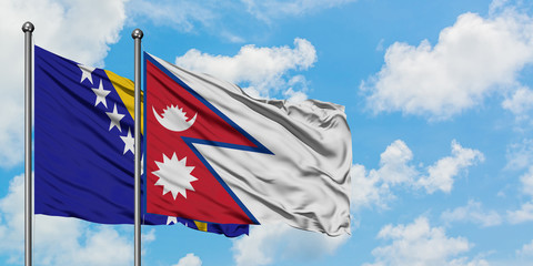 Bosnia Herzegovina and Nepal flag waving in the wind against white cloudy blue sky together. Diplomacy concept, international relations.