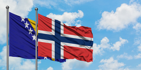 Bosnia Herzegovina and Norway flag waving in the wind against white cloudy blue sky together....
