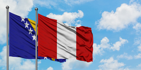 Bosnia Herzegovina and Peru flag waving in the wind against white cloudy blue sky together. Diplomacy concept, international relations.