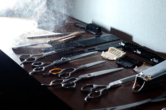scissors, razor, trimmer and nozzles lie on a wooden table, a set of barber equipment, hairdresser tools