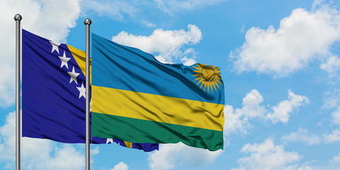 Bosnia Herzegovina and Rwanda flag waving in the wind against white cloudy blue sky together. Diplomacy concept, international relations.