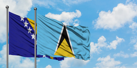Bosnia Herzegovina and Saint Lucia flag waving in the wind against white cloudy blue sky together. Diplomacy concept, international relations.