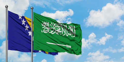 Bosnia Herzegovina and Saudi Arabia flag waving in the wind against white cloudy blue sky together. Diplomacy concept, international relations.