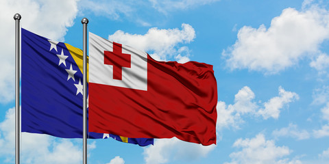 Bosnia Herzegovina and Tonga flag waving in the wind against white cloudy blue sky together. Diplomacy concept, international relations.